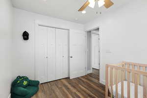 Bedroom featuring a crib, dark wood-style floors, a closet, ceiling fan, and recessed lighting