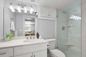 Bathroom with vanity, a stall shower, and a textured ceiling