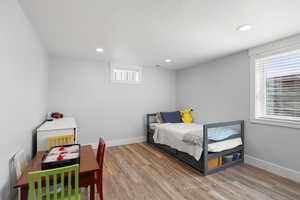 Bedroom with wood finished floors, recessed lighting, and a textured ceiling