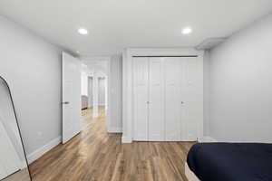 Bedroom featuring a closet, wood finished floors, and recessed lighting