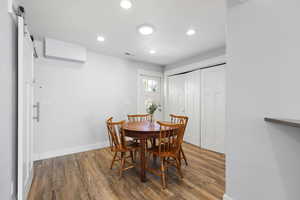 Dining area with dark wood-style floors and recessed lighting