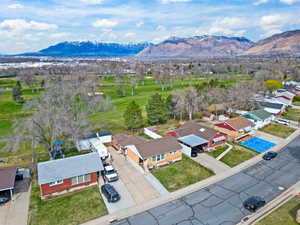 Aerial view of residential area featuring mountains and a golf course