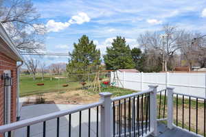 Wooden deck featuring a fenced backyard and a playground