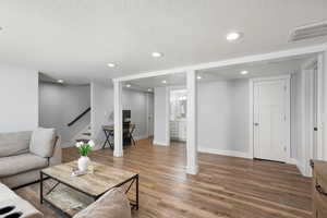 Living area featuring a textured ceiling, recessed lighting, and wood finished floors