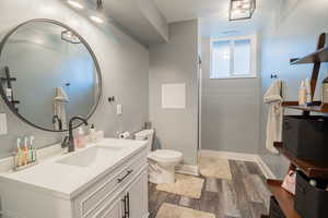 Bathroom featuring dark wood-style flooring, vanity, walk in shower, and a textured ceiling