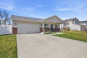 View of front of property featuring brick siding, a porch, concrete driveway, and a garage
