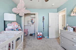Bedroom featuring light carpet, a closet, and ceiling fan