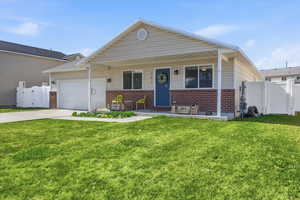 View of front of house with a gate, covered porch, brick siding, concrete driveway, and an attached garage