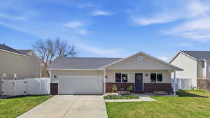 View of front facade featuring a gate, brick siding, a porch, an attached garage, and concrete driveway