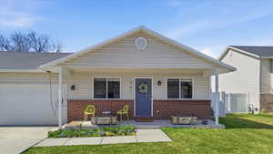 View of front of property with covered porch, brick siding, an attached garage, and driveway