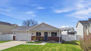 View of front of house featuring a gate, a porch, brick siding, a garage, and driveway