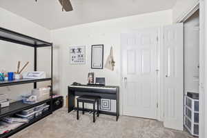 Home office featuring light colored carpet and ceiling fan