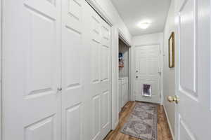 Laundry area with light wood finished floors and washing machine and clothes dryer