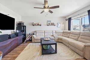 Living room featuring ceiling fan and wood finished floors