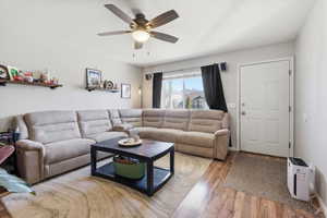 Living area featuring wood finished floors and ceiling fan