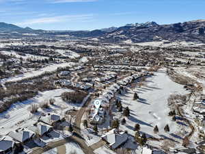 Snowy aerial view with a mountain view and a residential view