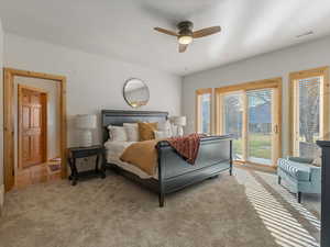 Bedroom featuring access to exterior, ceiling fan, and light carpet