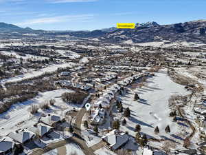 Snowy aerial view featuring a mountain view and a residential view