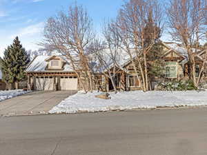 View of front of house with stone siding, a garage, and concrete driveway