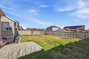 Fenced backyard featuring a residential view and a patio