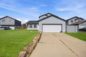 View of front facade featuring driveway and an attached garage