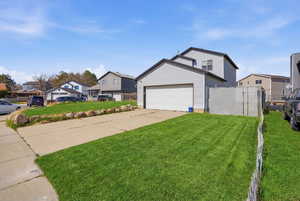 View of home's exterior with concrete driveway, a residential view, and an attached garage