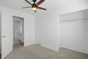 Unfurnished bedroom featuring light carpet and a ceiling fan