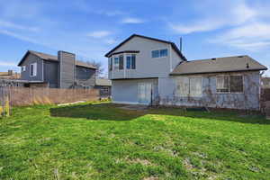 Back of property with a fenced backyard and roof with shingles