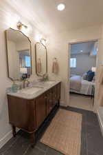 Bathroom with ensuite bath, double vanity, and recessed lighting