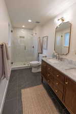 Full bathroom with double vanity, a stall shower, and recessed lighting