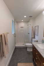 Bathroom with a stall shower, vanity, and recessed lighting