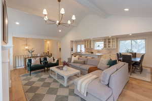 Living area with suspended lighting and light wood-type flooring