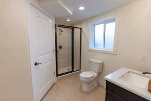 Full bathroom with vanity, a shower stall, and recessed lighting