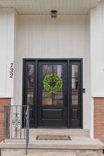 Doorway to property featuring brick siding