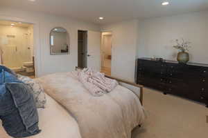 Carpeted bedroom with recessed lighting, ensuite bath, and a spacious closet