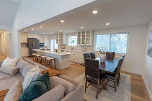 Dining room featuring light wood-type flooring, recessed lighting, and a high ceiling