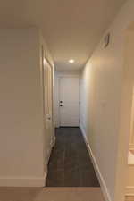 Corridor featuring recessed lighting and dark marble finish floors