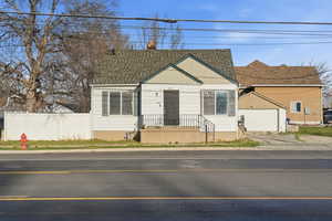 View of front of property featuring a garage, board and batten siding, a chimney, and an outbuilding