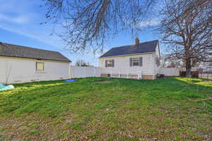 Back of property with a chimney and a fenced backyard
