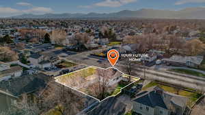 Aerial view of residential area featuring property boundaries highlighted and a mountain backdrop