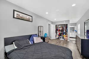 Bedroom featuring light wood-type flooring, a closet, recessed lighting, and ensuite bathroom
