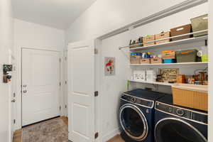 Laundry area featuring washing machine and dryer and light wood-style floors