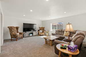 Carpeted living area featuring recessed lighting and baseboards