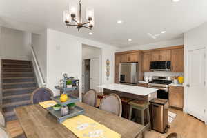 Dining space with light wood-style flooring and a chandelier