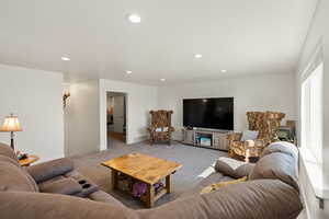 Carpeted living area featuring recessed lighting and baseboards