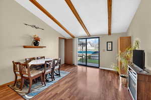 Dining space with lofted ceiling with beams