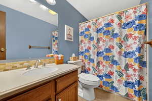 Bathroom featuring vanity, light tile patterned flooring, a shower with curtain, and backsplash