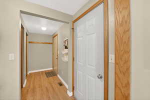 Hallway with baseboards and light wood-style floors