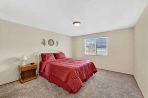 Bedroom featuring carpet and baseboards