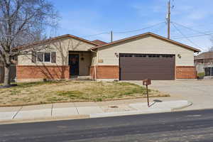 View of front of house with brick, siding, a garage, and concrete driveway